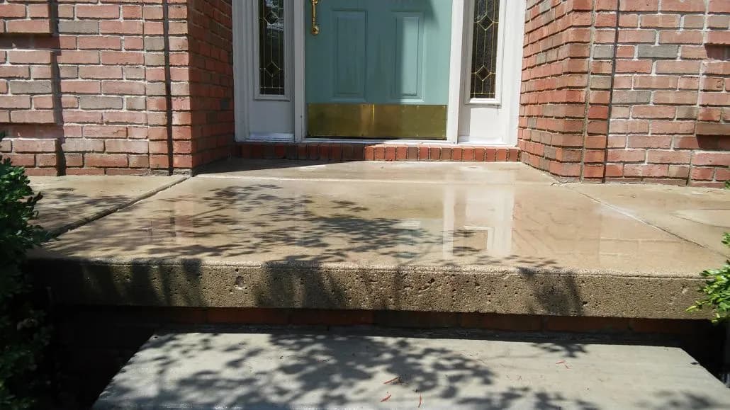 Clean concrete porch with a green door